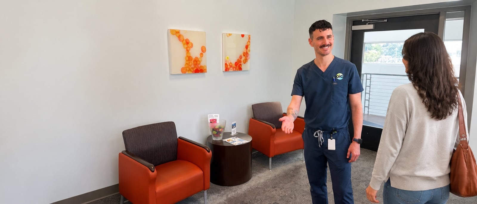 Contact Orlando Immunology Center — staff member welcoming a patient